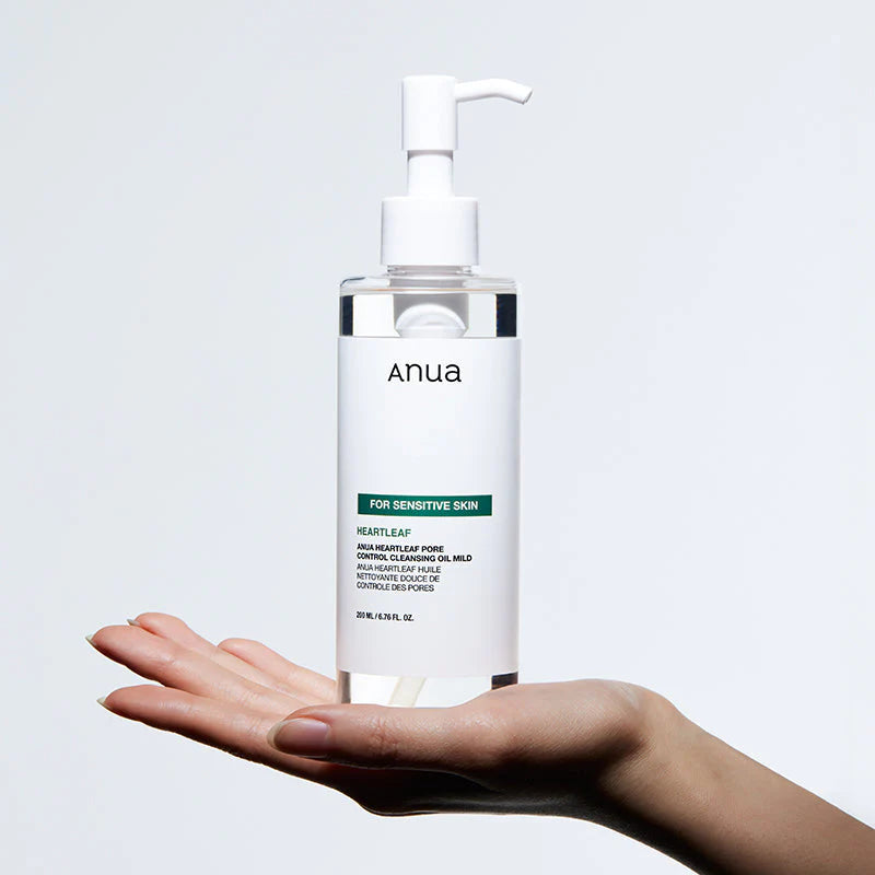 Applying Anua Heartleaf Cleansing Oil Mild pump cleanser onto hands for gentle makeup removal and pore cleansing