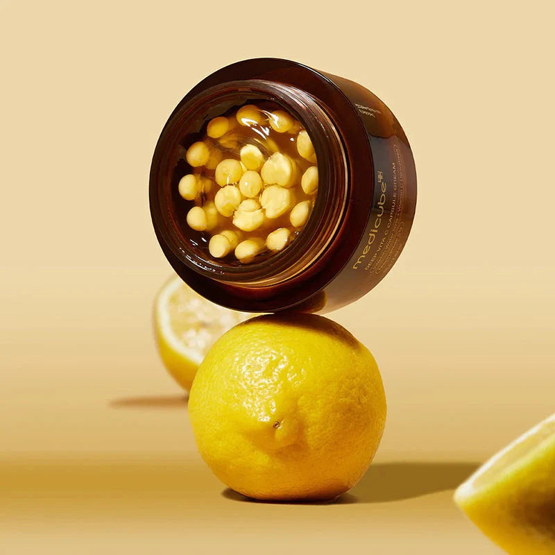 medicube Deep Vita C Capsule Cream jar balanced on lemon vitamin glow boosting skincare product