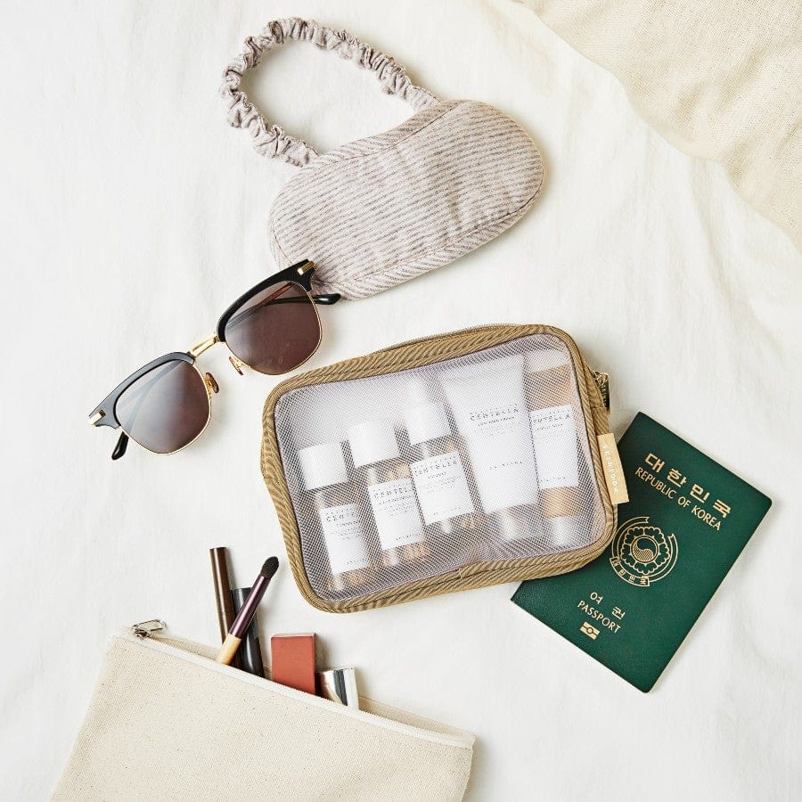 SKIN1004 Madagascar Centella Travel Kit flat lay with pouch passport and sunglasses travel skincare essentials