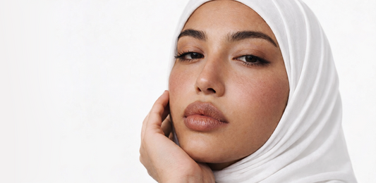 Woman applying Korean skincare, glowing skin, hijab, Saudi Arabia