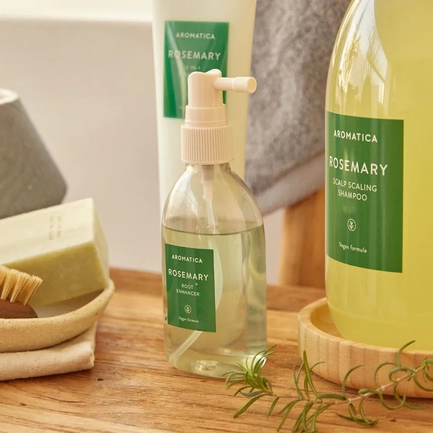 Aromatica Rosemary hair care products on a wooden surface with a neutral background