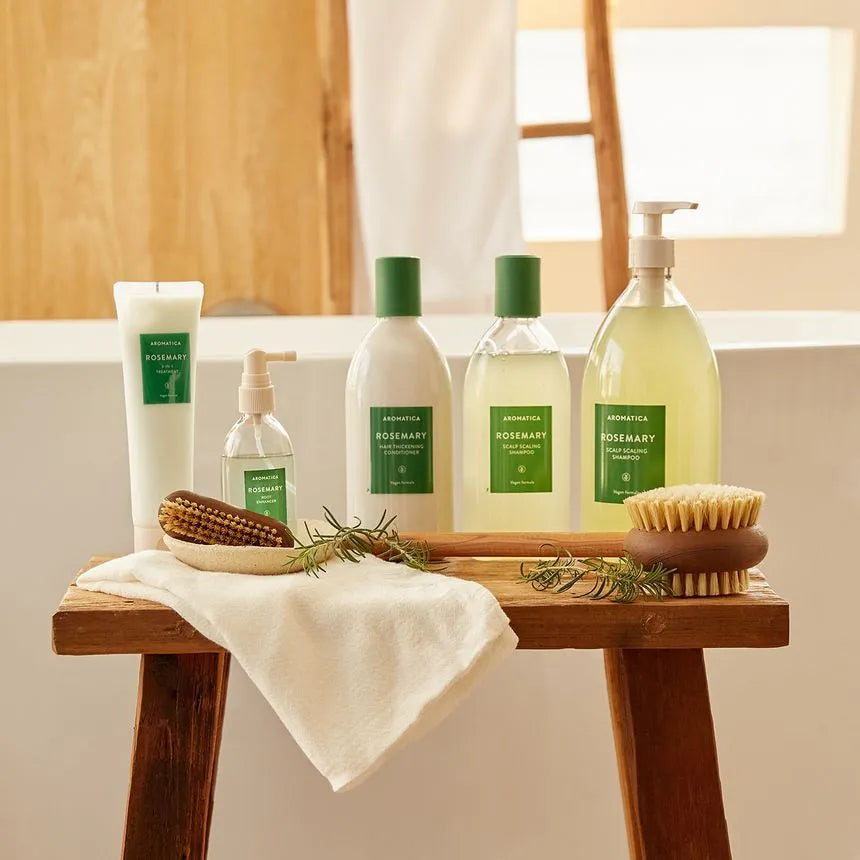 Bath products including bottles, a tube, and a brush on a wooden table with a neutral background.