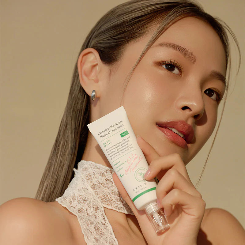 Beauty model holding AXIS-Y Complete No-Stress Physical Sunscreen SPF50+