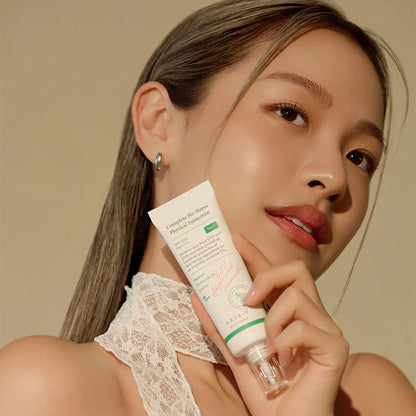 Beauty model holding AXIS-Y Complete No-Stress Physical Sunscreen SPF50+