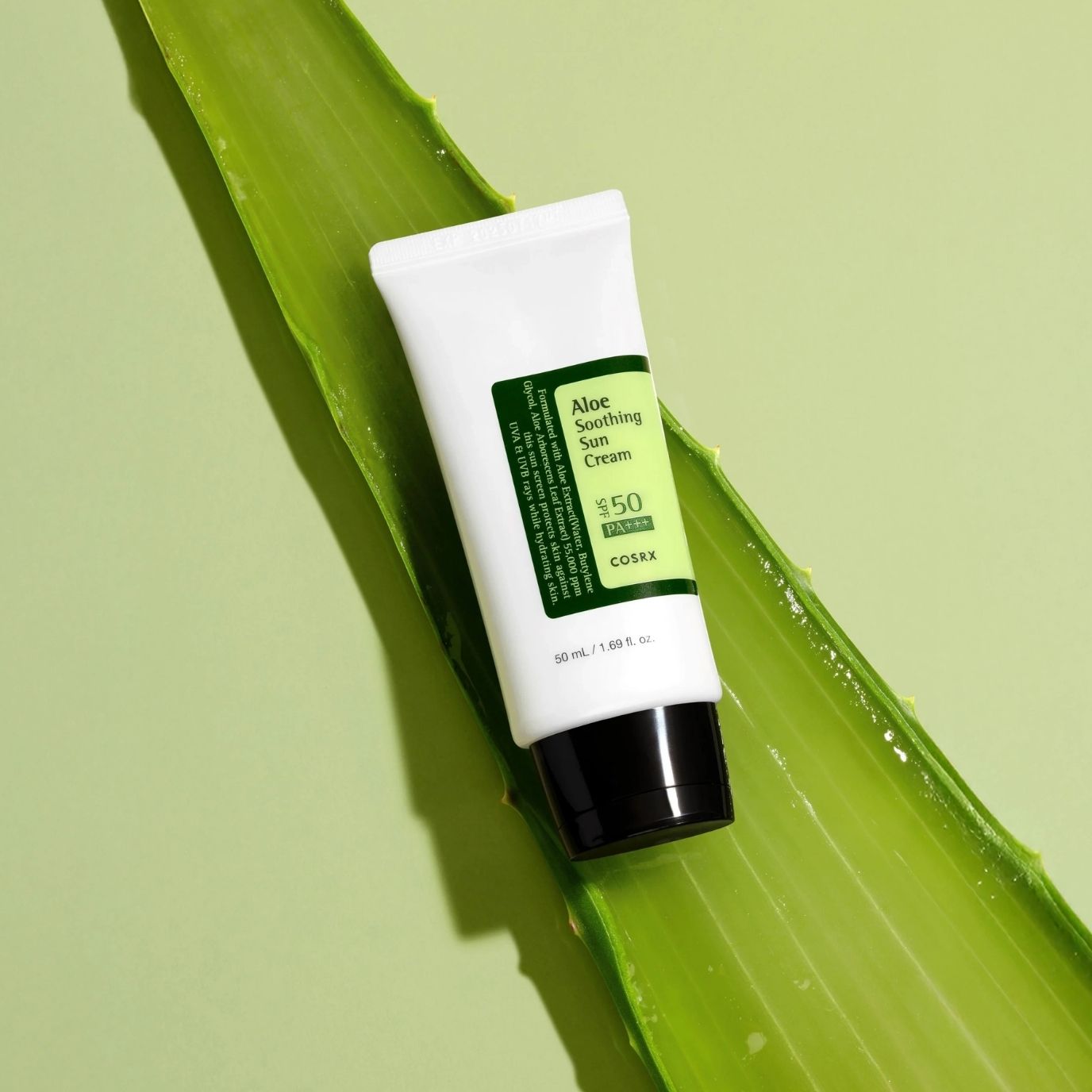 COSRX Aloe Soothing Sun Cream SPF50+ PA+++ placed on fresh aloe leaf highlighting soothing aloe vera ingredients and hydrating UV protection