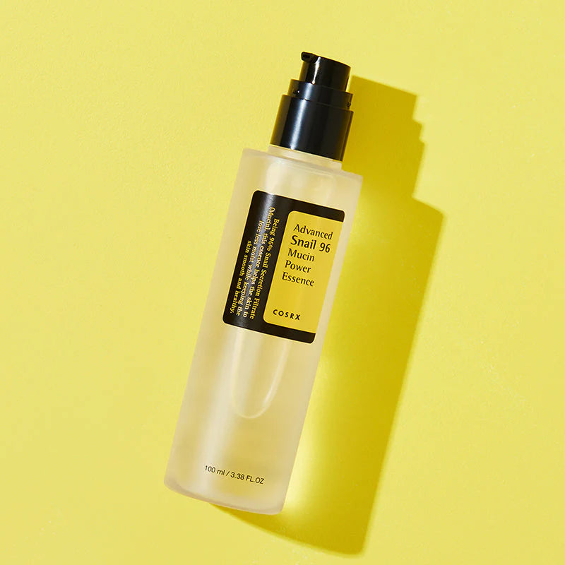 COSRX Snail Mucin Essence bottle with glowing yellow background highlighting Korean skincare for radiant glass skin