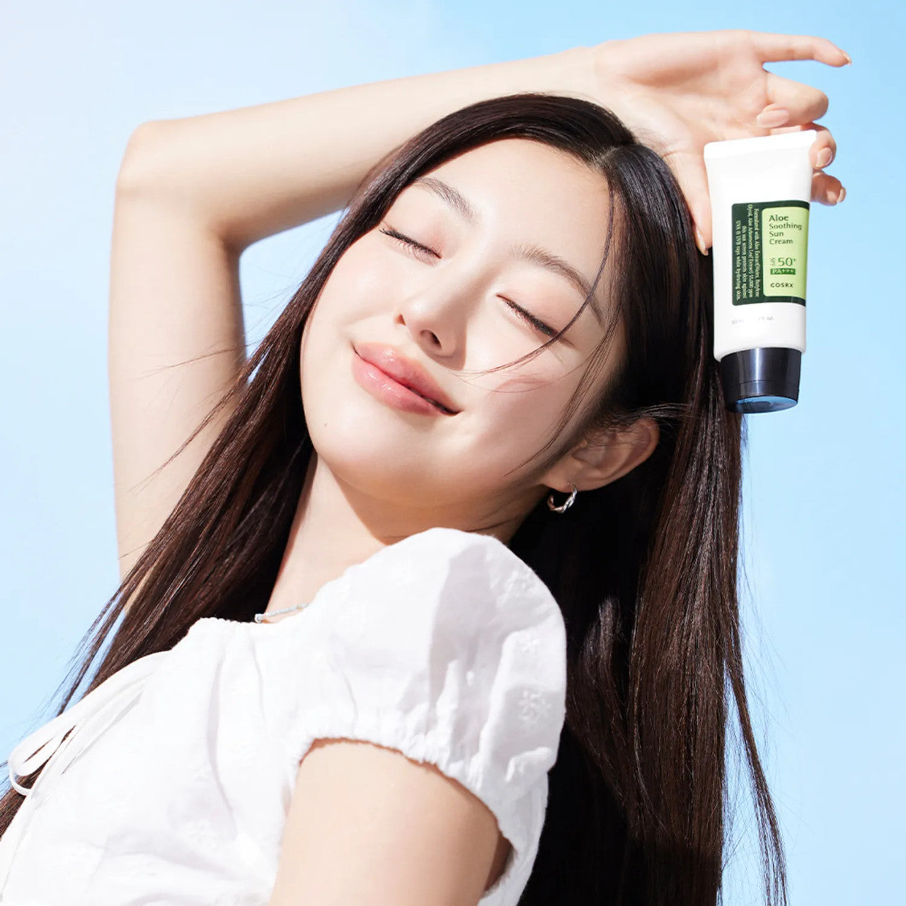 Model holding COSRX Aloe Soothing Sun Cream SPF50+ PA+++ demonstrating radiant protected skin and daily Korean sunscreen use