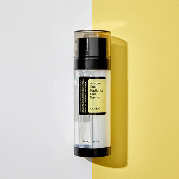 COSRX Advanced Snail Radiance Dual Essence bottle with dual-layer formula packaging on yellow and white background