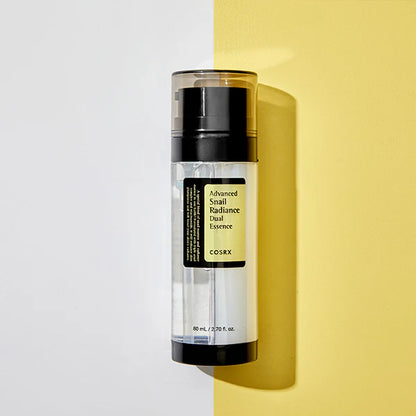 COSRX Advanced Snail Radiance Dual Essence bottle with dual-layer formula packaging on yellow and white background