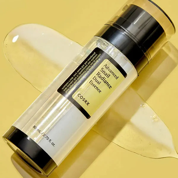 Close-up of COSRX Advanced Snail Radiance Dual Essence pump bottle with glossy serum texture for radiant skin