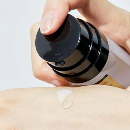 Hand dispensing COSRX Advanced Snail Radiance Dual Essence serum onto skin for hydration and elasticity care