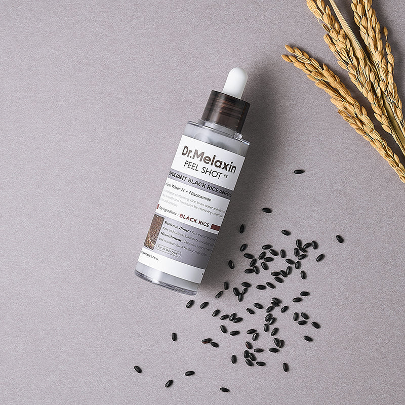 Dr. Melaxin Black Rice ampoule with rice grains highlighting exfoliating and nourishing ingredients